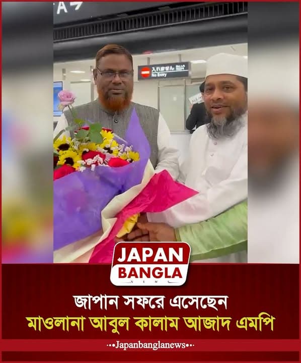 At an airport arrivals area, a man in a white cap and traditional white robe presents a bouquet of sunflowers and pink flowers wrapped in colorful paper to a man in a grey vest and dark shirt, both smiling near a sign reading "No Entry".