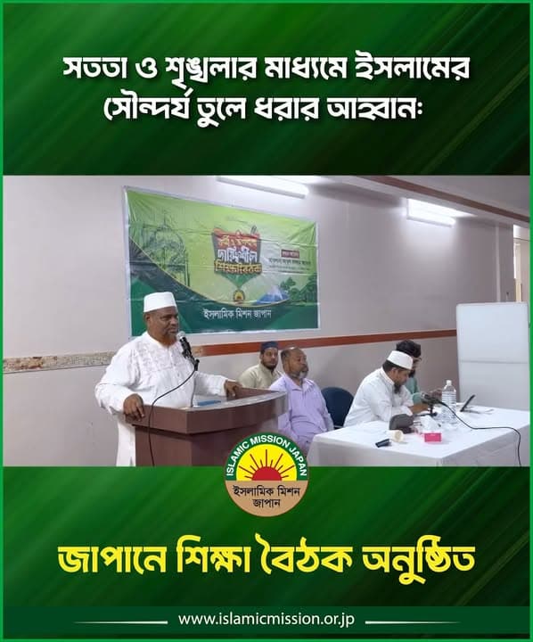 A speaker in a white kurta and cap addresses attendees from a podium at a training session, with a green Islamic Mission Japan banner behind him and three seated participants at a table beside him.